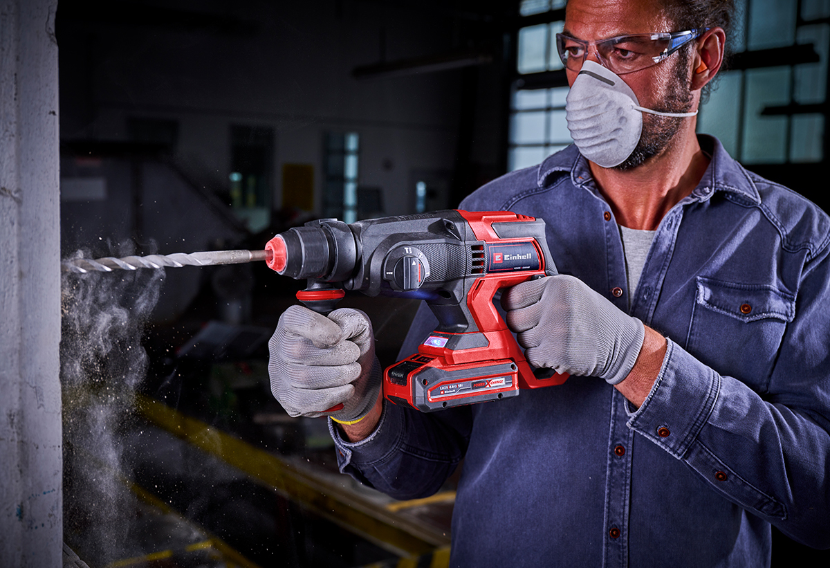 Απεικονίζεται άντρας να χρησιμοποιεί το πιστολέτο για εργασία στον τοίχο.